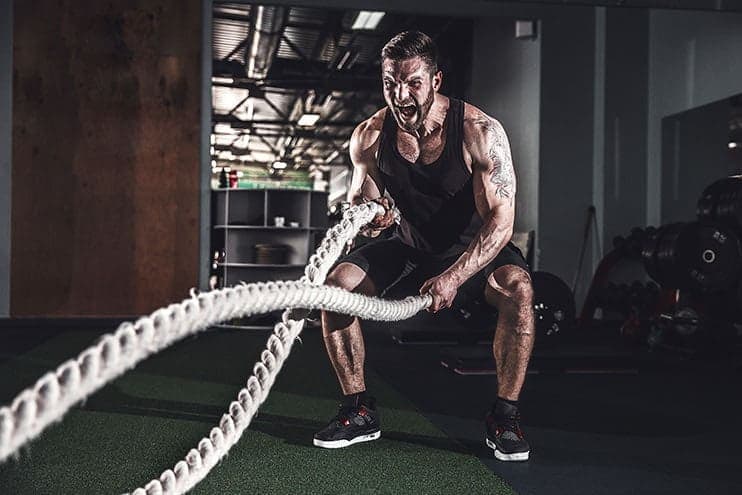 Muscular Guy Using Battle Ropes In The Gym
