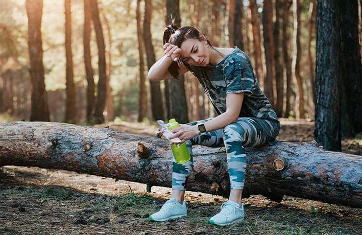 Girl Sitting On Log Recovering After Workout