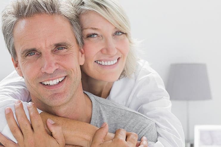 Healthy Man Smiling While His Wife Hugs Him