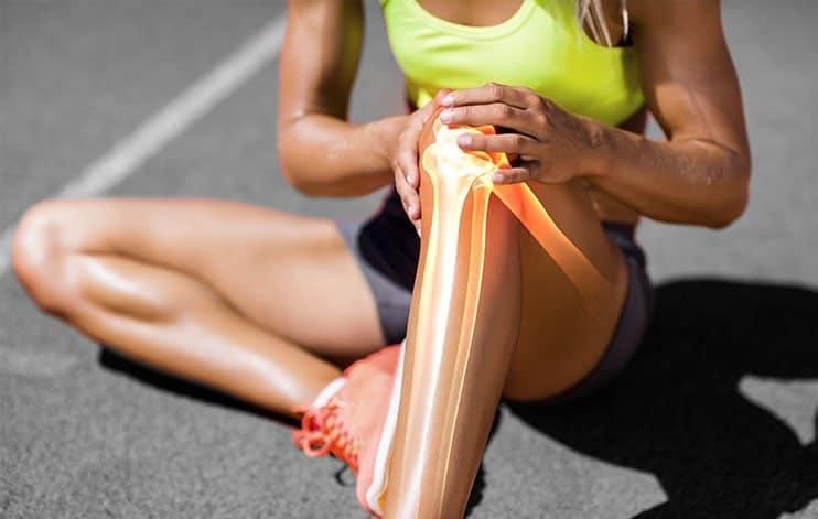 Sitting Woman In Green Tanktop Holding Her Knee