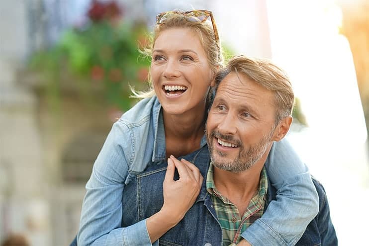 Middle Aged Man And Woman Hugging And Smiling