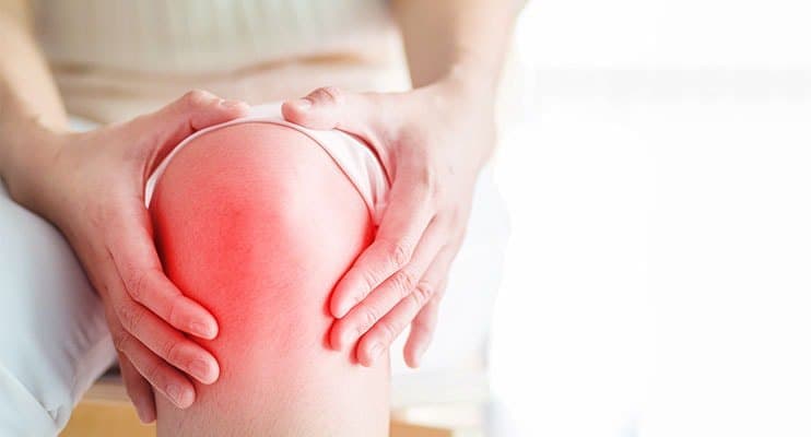 Man Holding His Hands Around His Inflamed Knee